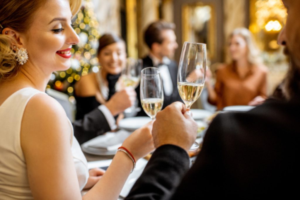 Festive family and friends in smart attire, toasting Christmas day